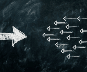 Weiße Pfeile schwimmen im Wasser in eine Richtung – Symbol für Klarheit, Ausrichtung und Resilienz.