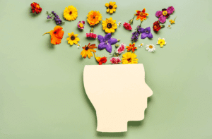 Mental Health Awareness: Illustration eines Kopfes mit bunten Blumen – Symbol für Gedanken, mentale Gesundheit und persönliches Wachstum.