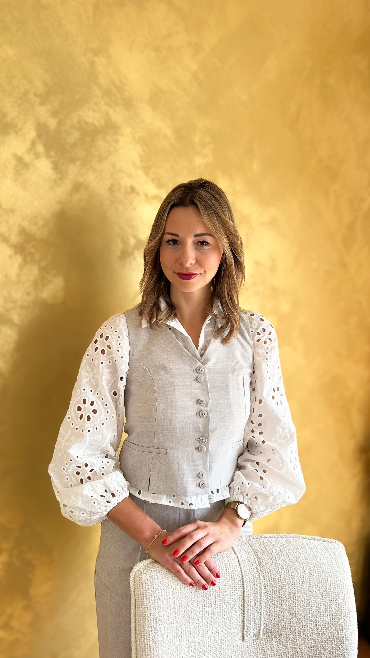 Sandra Freidl Mentaltrainerin aus Graz steht vor goldener Wand – Portrait für Mentaltraining Website