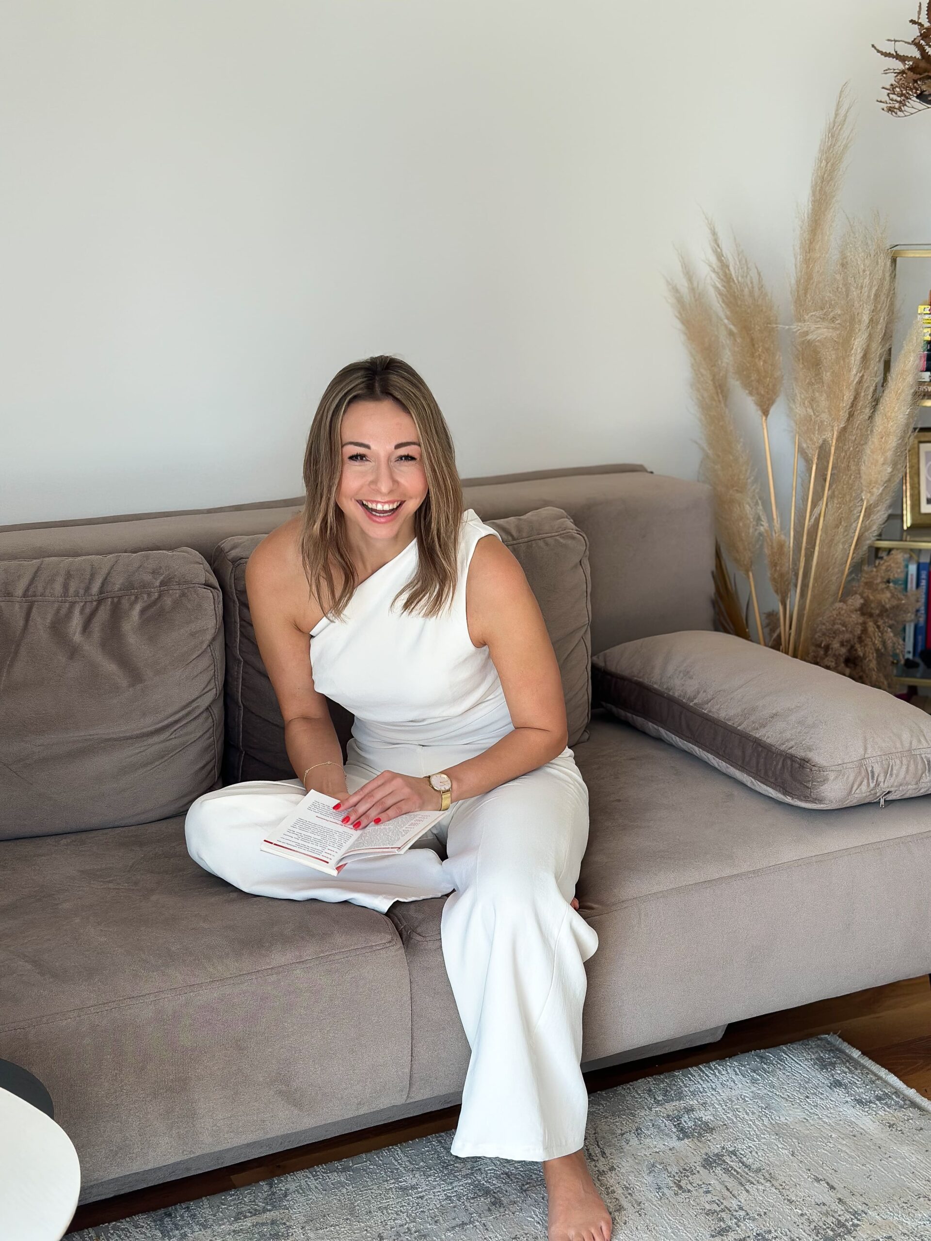 Mentaltraining Graz – Frau sitzt entspannt auf Sofa und reflektiert Gedanken für mehr mentale Stärke