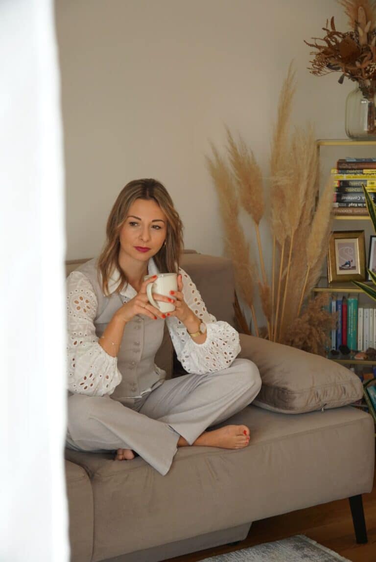 Frau sitzt entspannt auf Sofa und reflektiert ihre Gedanken im Mentaltraining