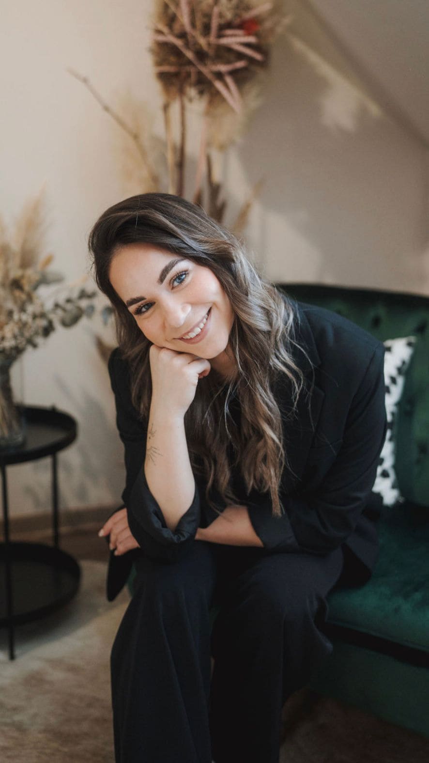 Milena Heschl lächelt sitzend in die Kamera – Porträtfoto für ein Kundinnen-Testimonial von Sandra Freidl Mentaltraining.