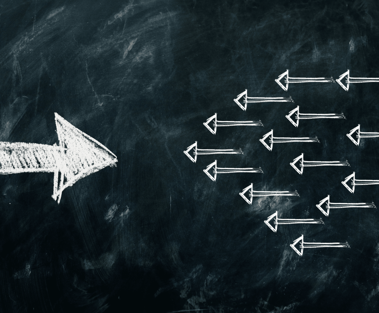 Weiße Pfeile schwimmen im Wasser in eine Richtung – Symbol für Klarheit, Ausrichtung und Resilienz.