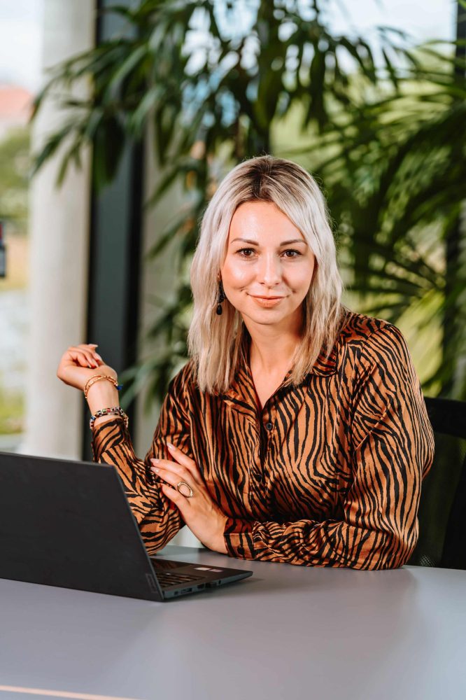 Sandra Freidl am Laptop mit offenem Blick – Businessportrait für Mentale Stärke & Selbstführung - das Mentaltraining in Graz.